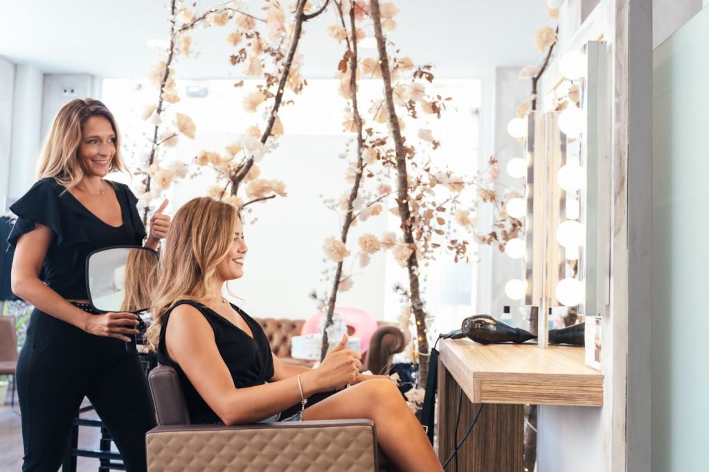 A client sees her finished hair at the end of a salon appointment.